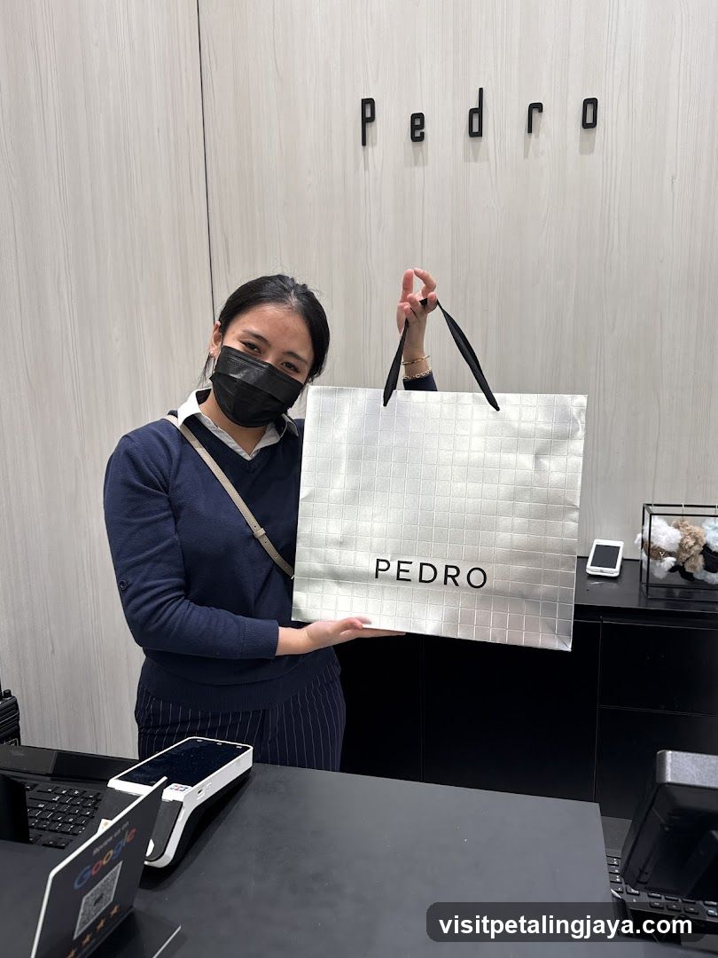 Staff holding Pedro shopping bag