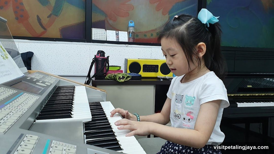 Young Girl Playing Keyboard in Music Room