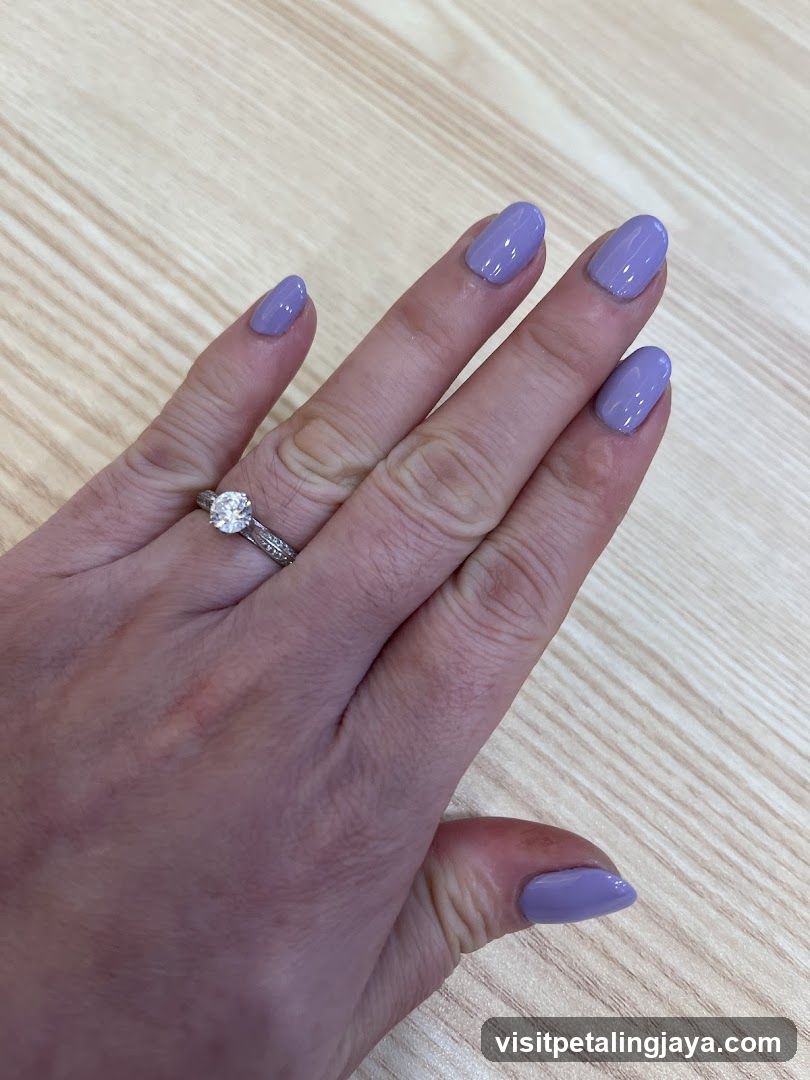 Hand with purple nail polish and rings