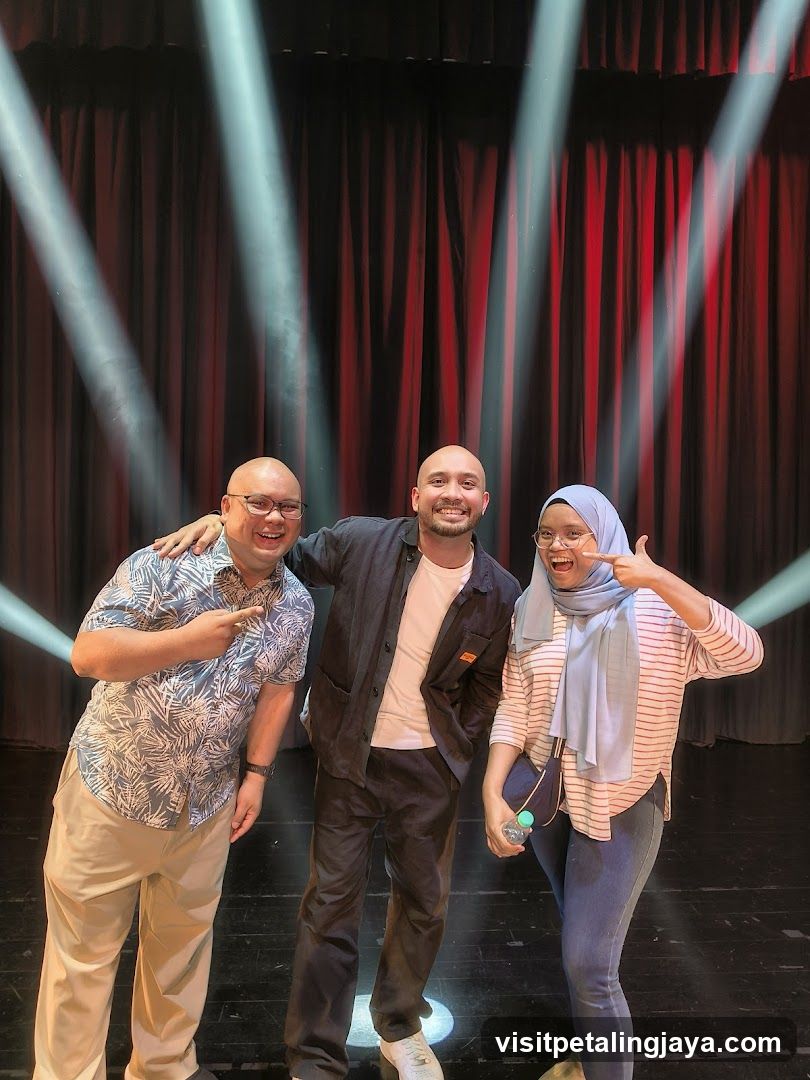 Three people on stage with spotlights