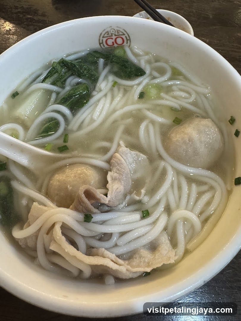 Bowl of Noodle Soup with Meatballs and Greens