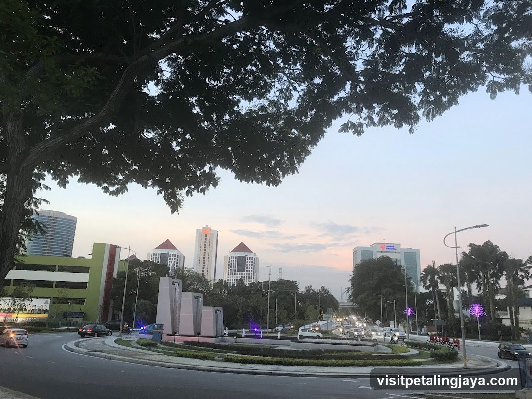 Roundabout at dusk with city skyline