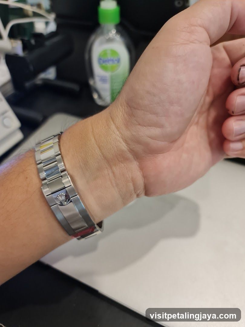 Hand with watch and bottle in background
