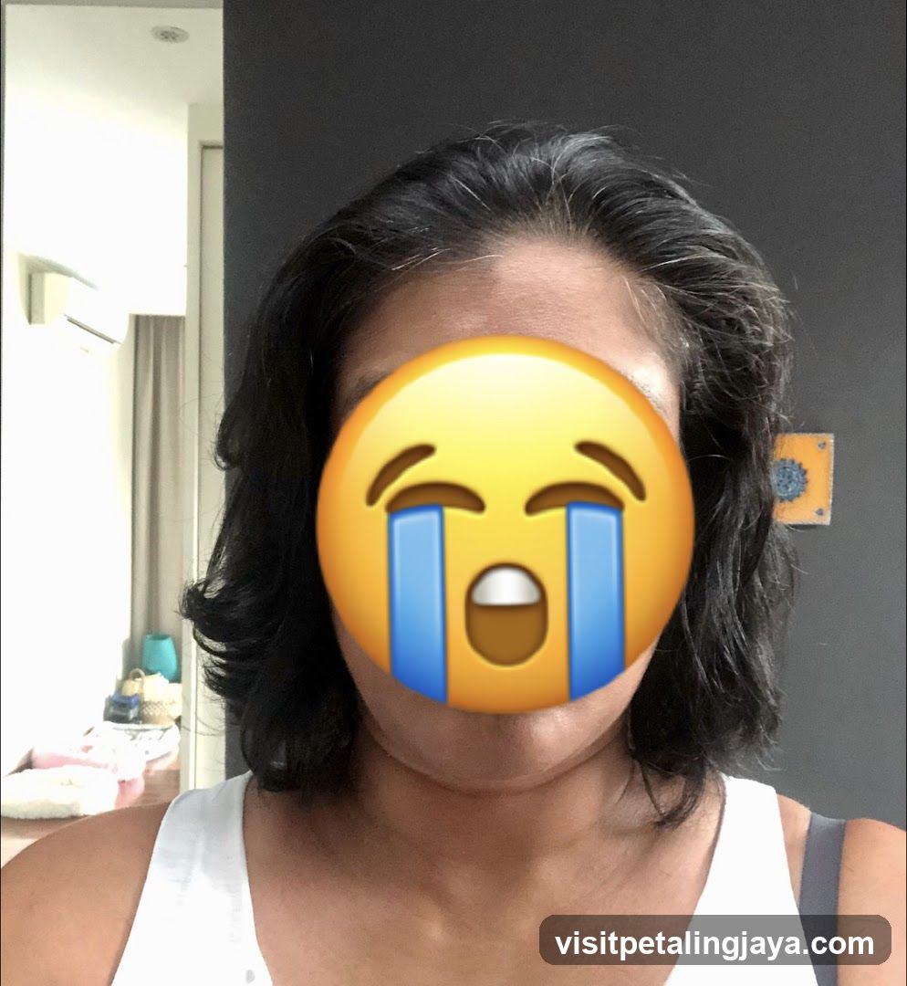 Person with crying emoji covering face