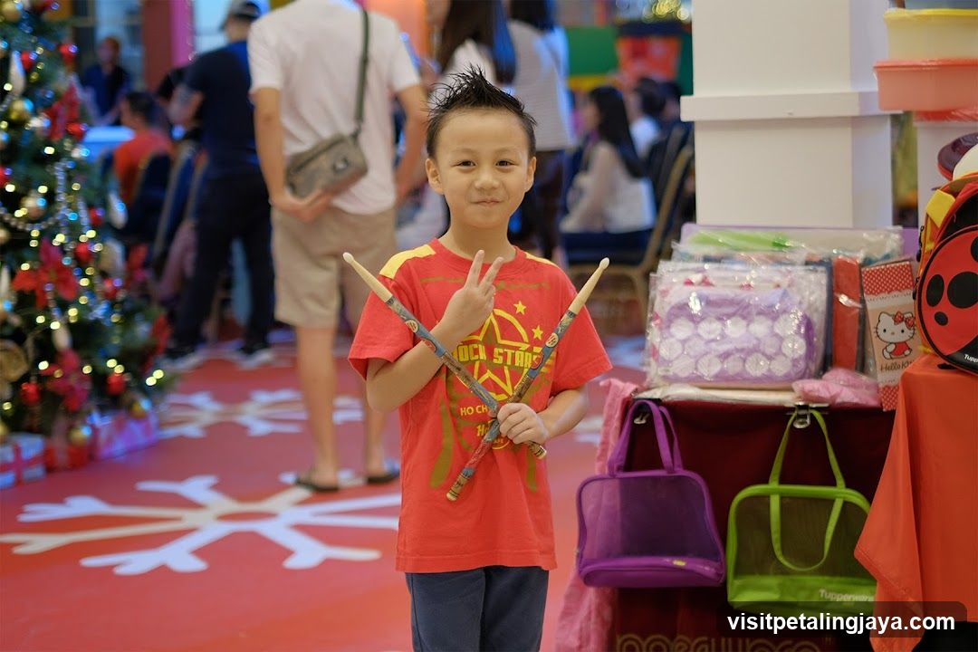 Child with drumsticks in mall