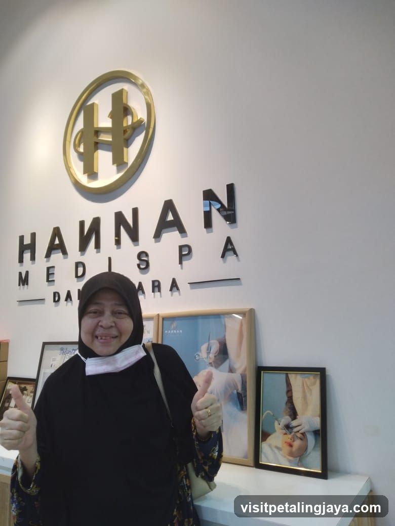 Woman giving thumbs up in front of spa sign