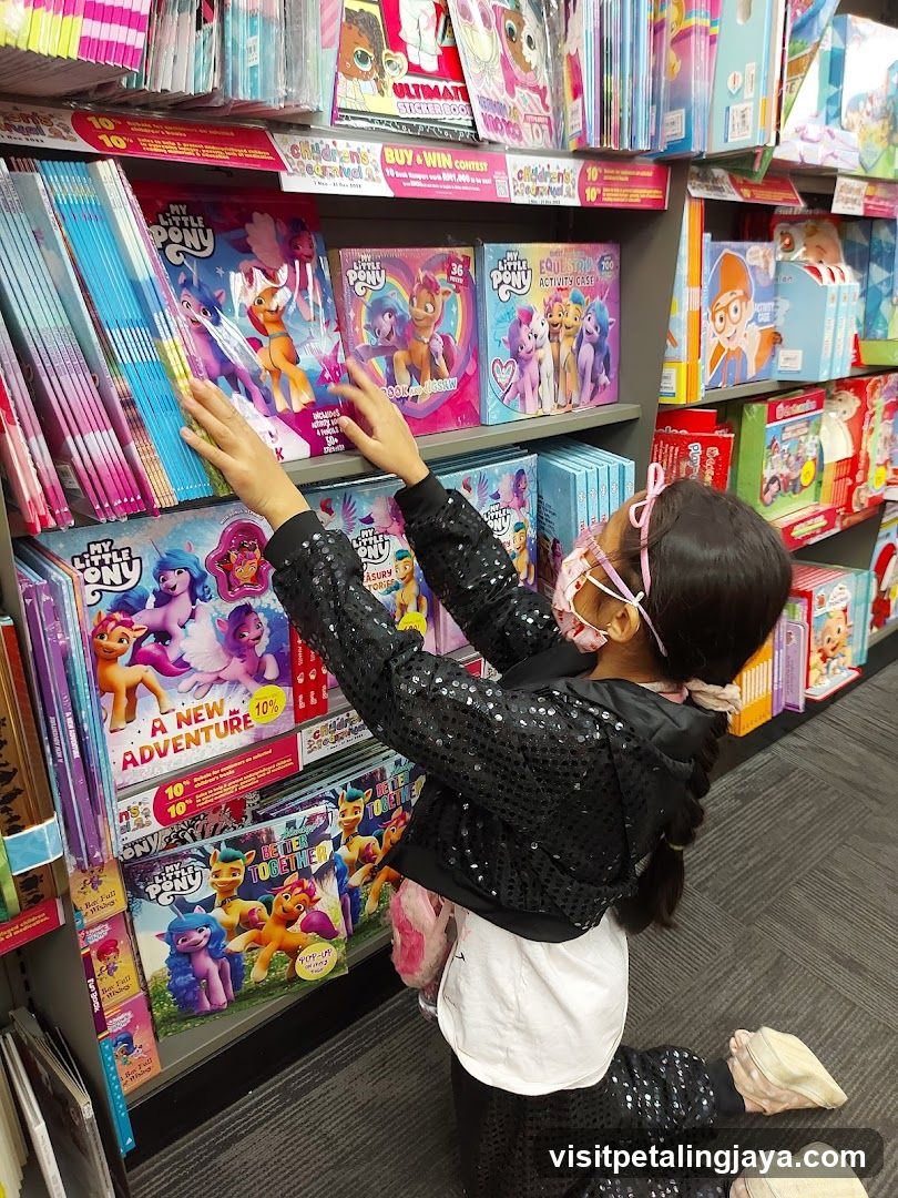 Child selecting My Little Pony books in store aisle