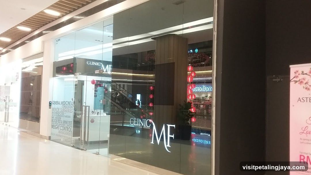 Glass-fronted medical clinic entrance with visible signage reading 'CLINIC MF' and service categories like general medicine, minor surgery, and weight control.