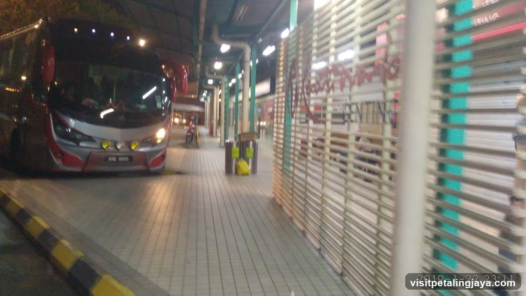 Bus at night with closed shop fronts