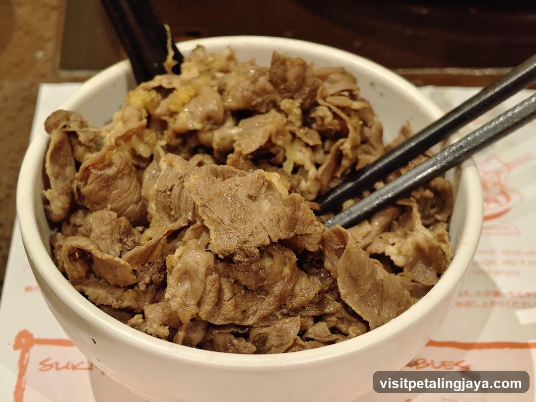 Bowl of cooked beef with chopsticks