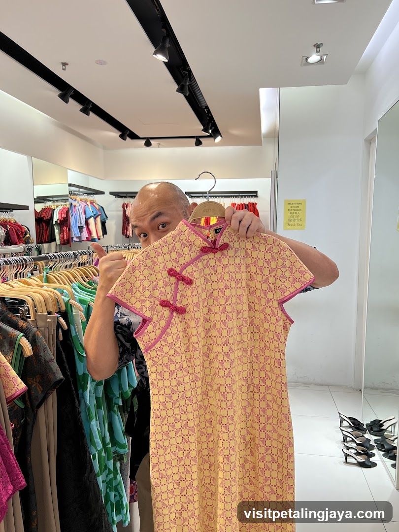 Man holding yellow patterned dress in clothing store