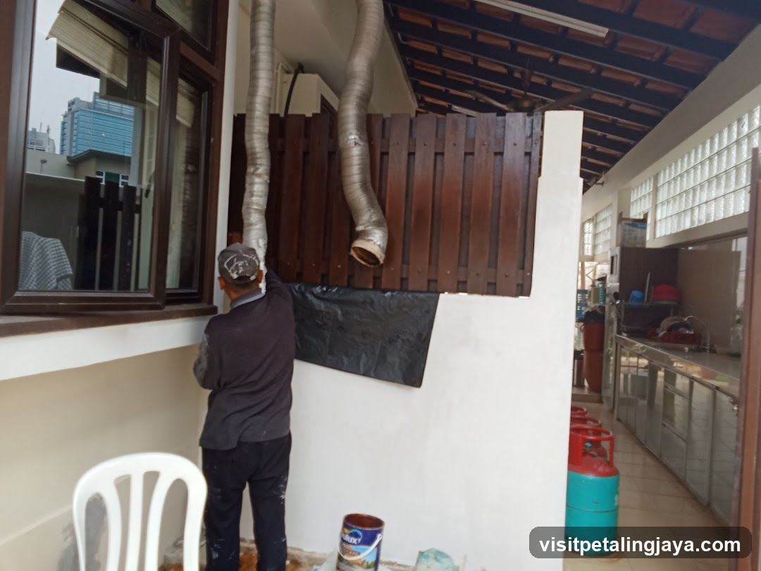 Worker installing ventilation ducts on building exterior