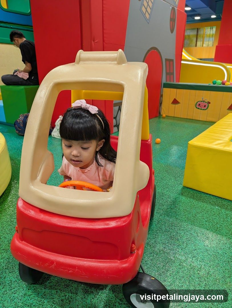 Child in toy car at indoor play area