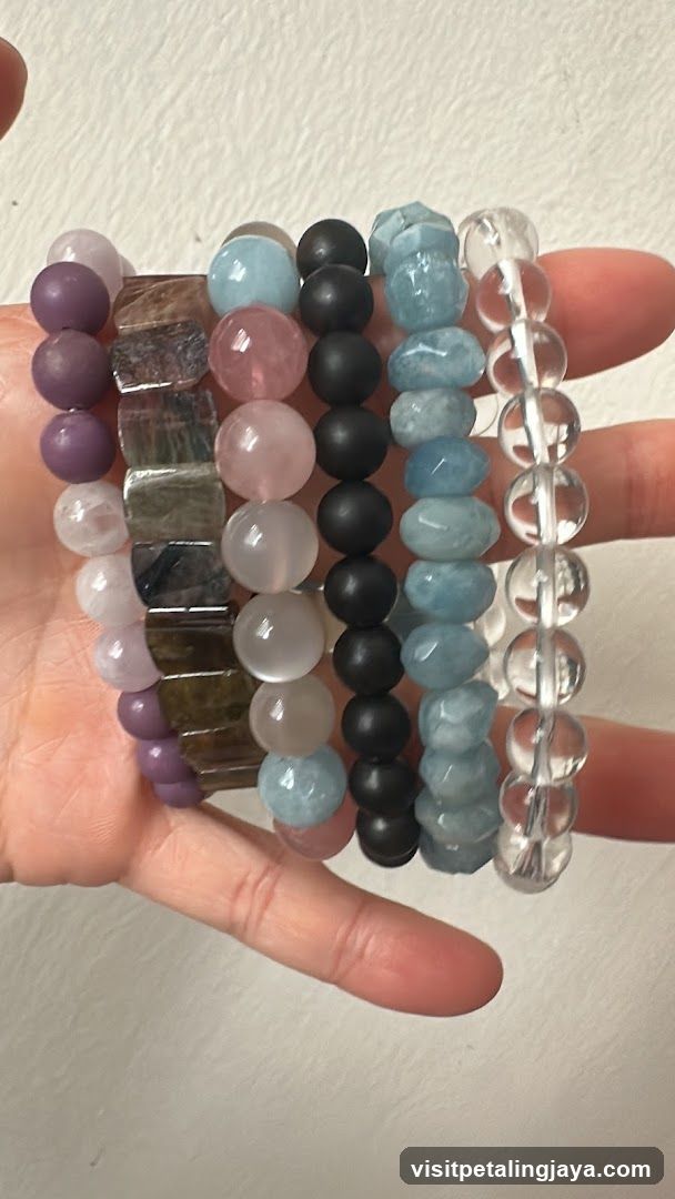 Hand holding five beaded bracelets