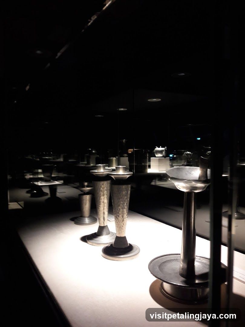 Display of metallic candlesticks in a dimly lit room