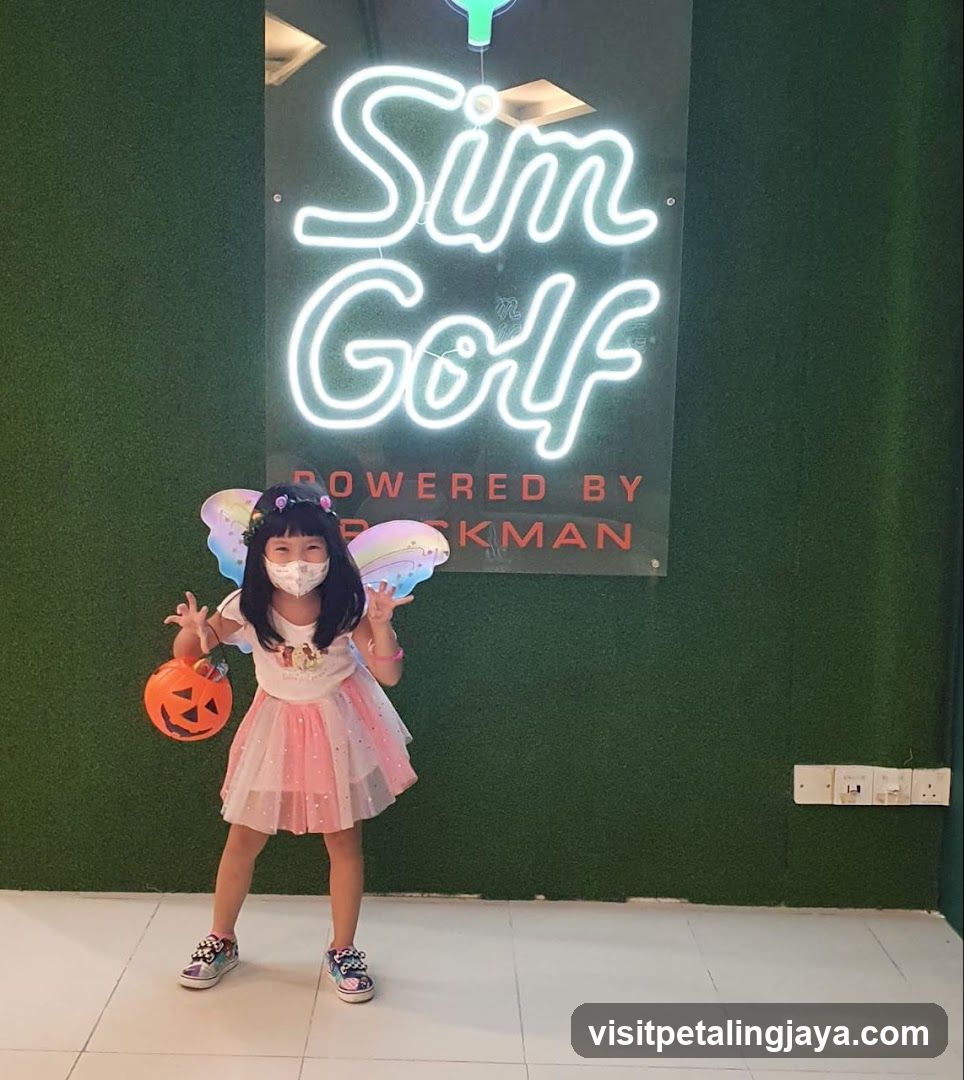Child in costume posing with pumpkin
