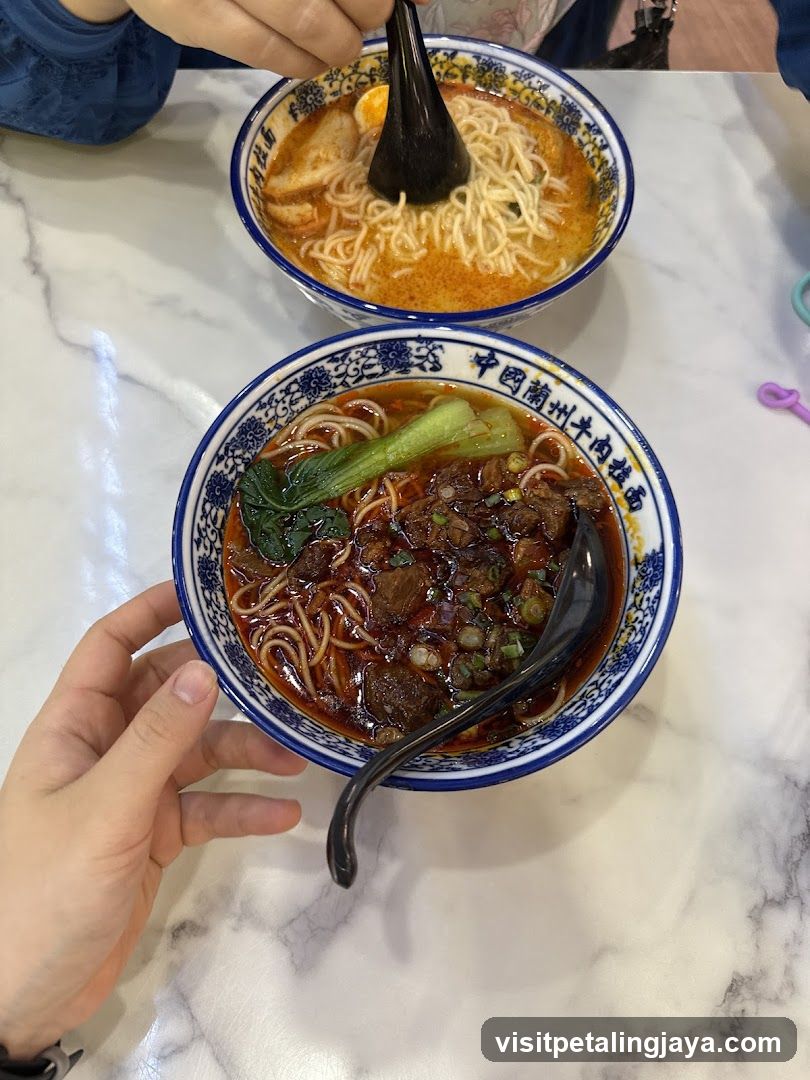 Two bowls of noodle soup on a marble table