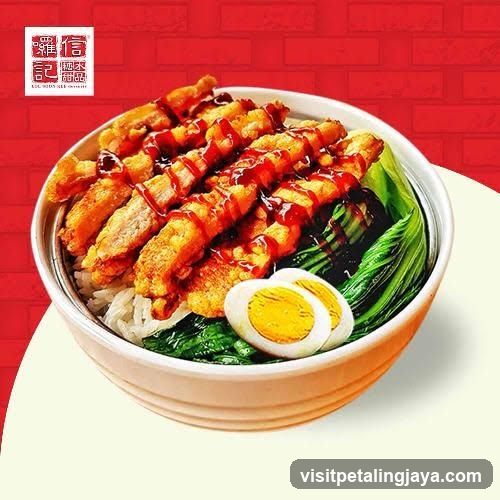 Bowl of fried chicken rice with egg and greens