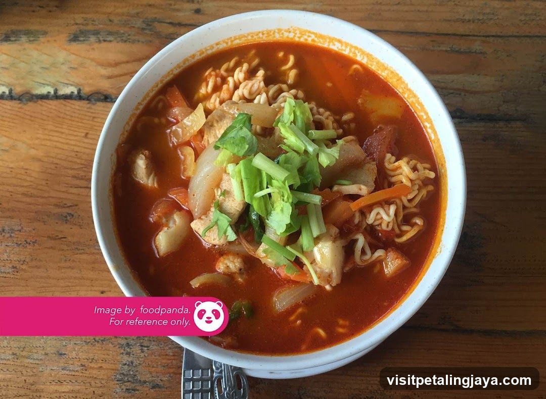 Bowl of spicy noodle soup with vegetables and greens