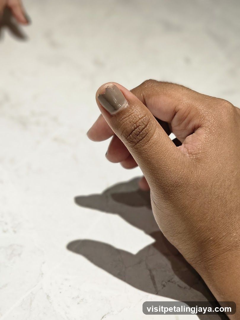 Hand with painted nails on marble surface