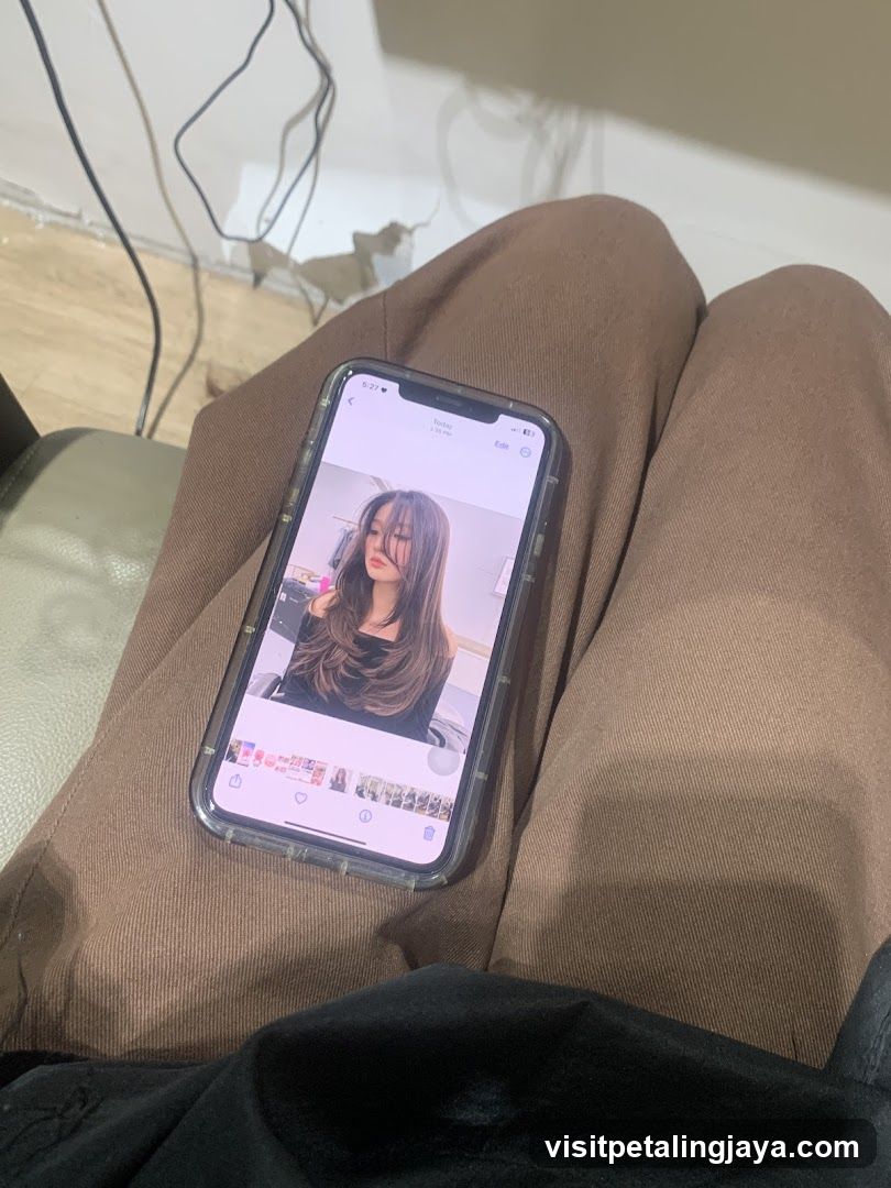 Phone showing hair style reference on lap