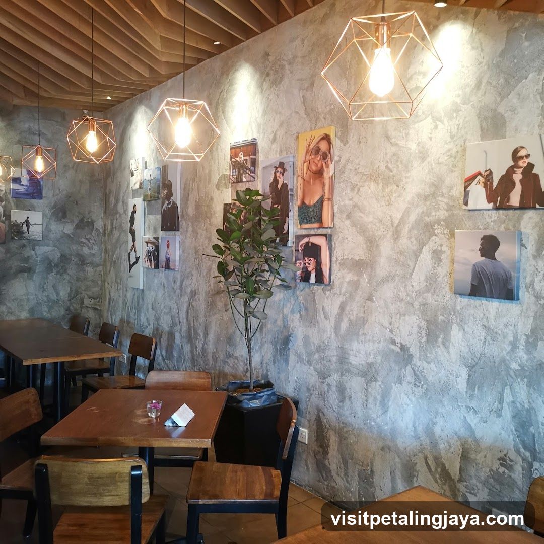 Interior of a cafe with concrete walls and framed photos