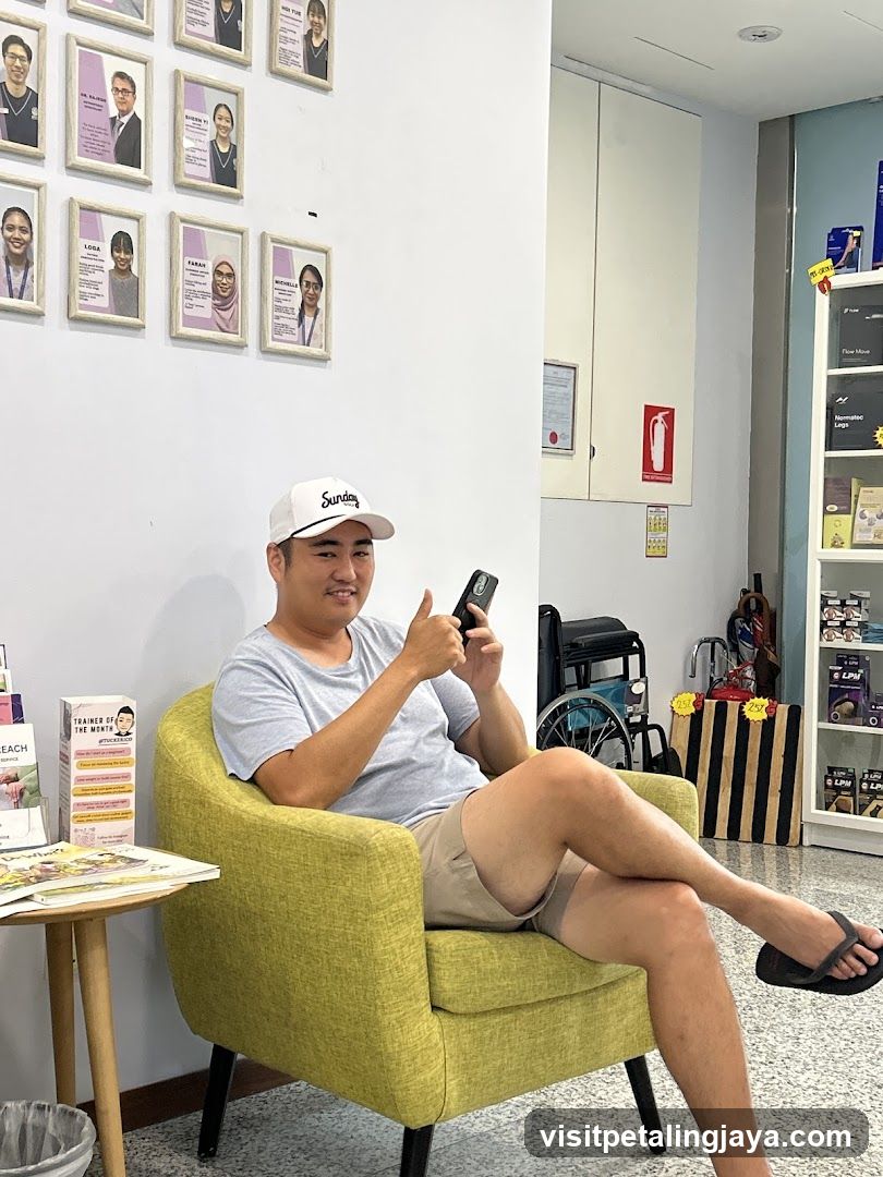 Man sitting in a green armchair holding phone