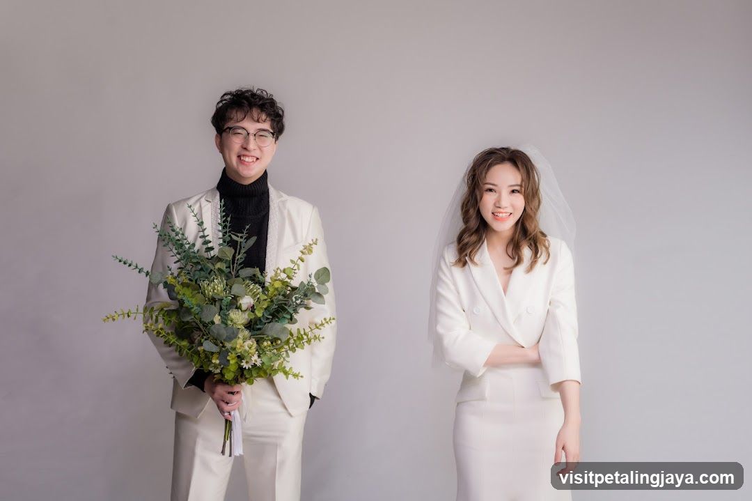 Couple in White Wedding Attire Holding Bouquet