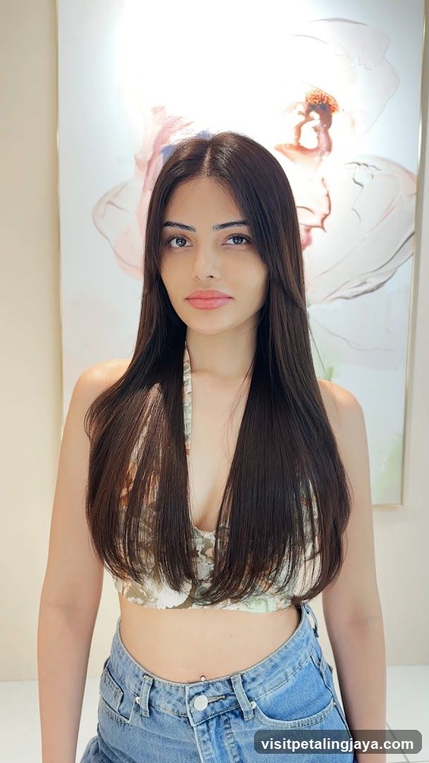 Portrait of a woman with long dark hair wearing a crop top and jeans