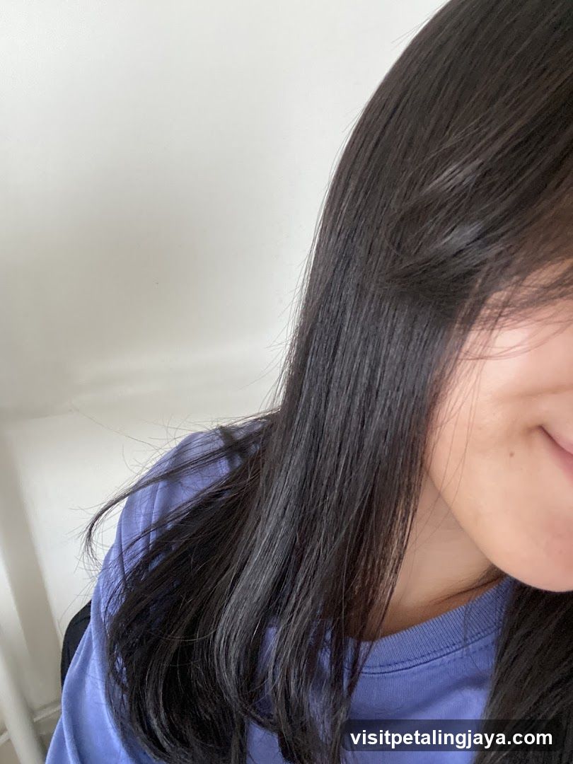 Person with long dark hair wearing a blue shirt