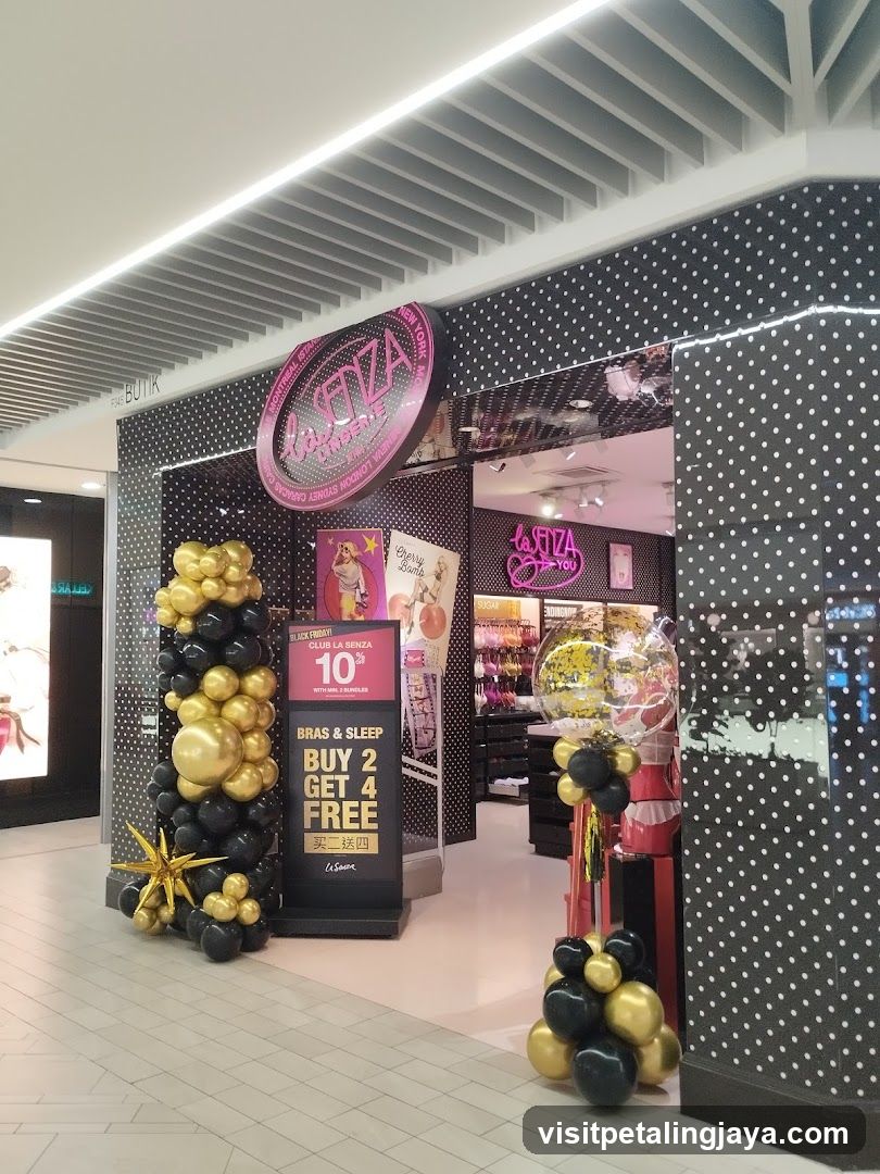 A storefront entrance featuring black and gold balloon decorations, a promotional sign offering 'Buy 2 Get 4 Free', and a visible shop sign with the brand name La Senza.