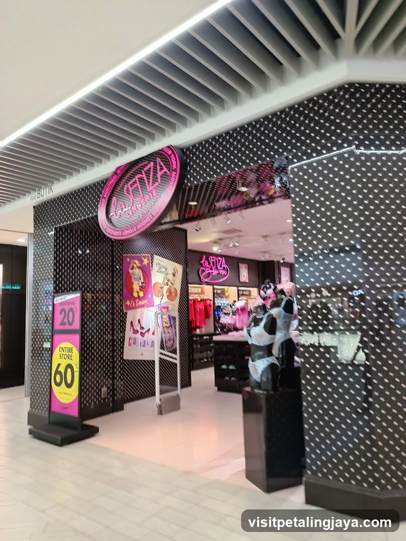 A modern shop front with black and white polka dot patterned walls. A large circular pink sign reads 'LA STRADA' above the entrance. Inside, there are mannequins dressed in fashion items, including a panda-themed outfit. Posters on the wall advertise products like shoes and clothing. A digital display outside shows a promotional message.