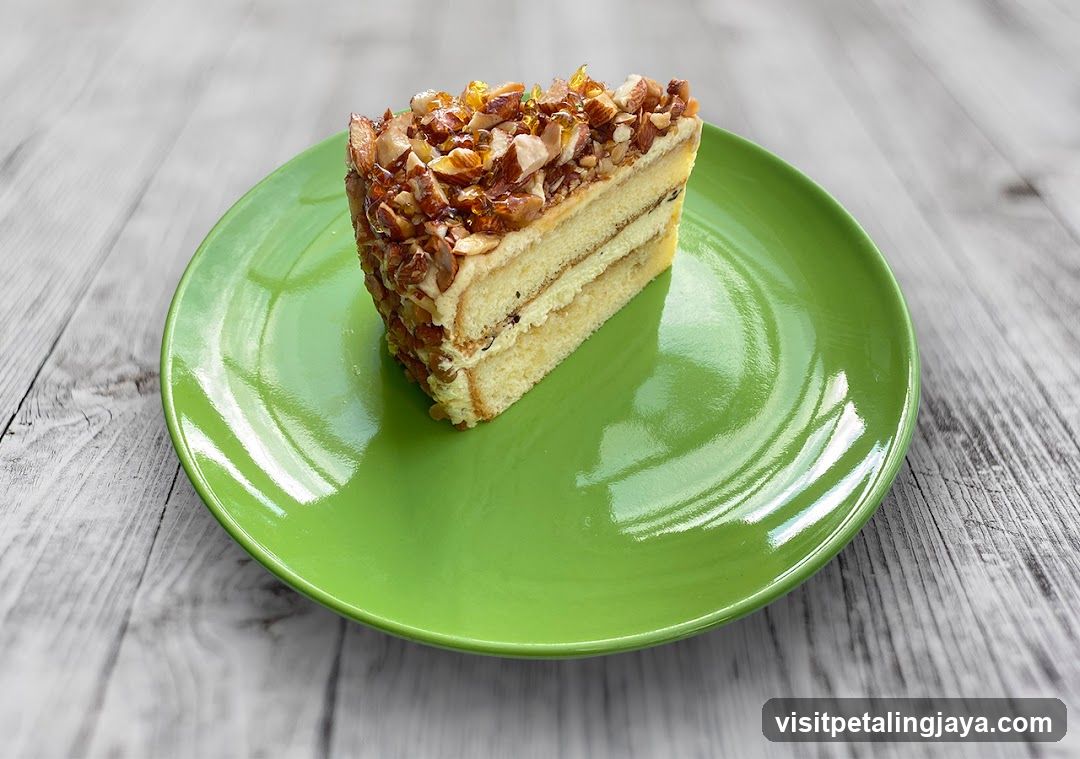 Slice of layered cake with caramelized topping on green plate