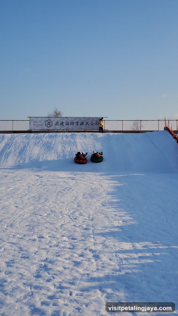 Snow tubing scene with signboard