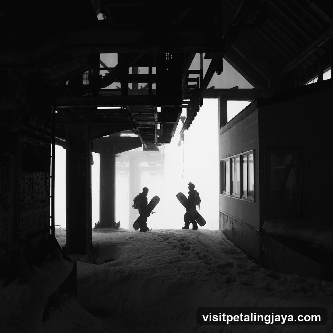 Silhouetted Snowboarders at Ski Resort Entrance