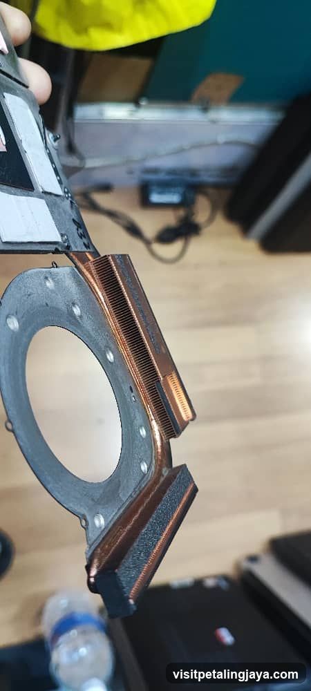 Close-up of a computer component with copper heat pipes and thermal pad