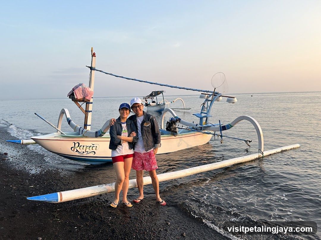 Couple with traditional boat at sunset