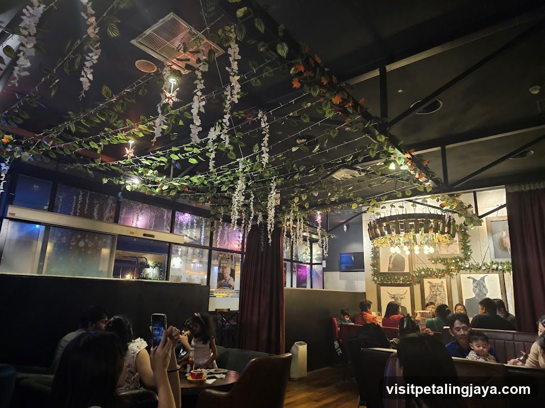 Interior of a cozy restaurant or cafe with decorative hanging plants and warm lighting.