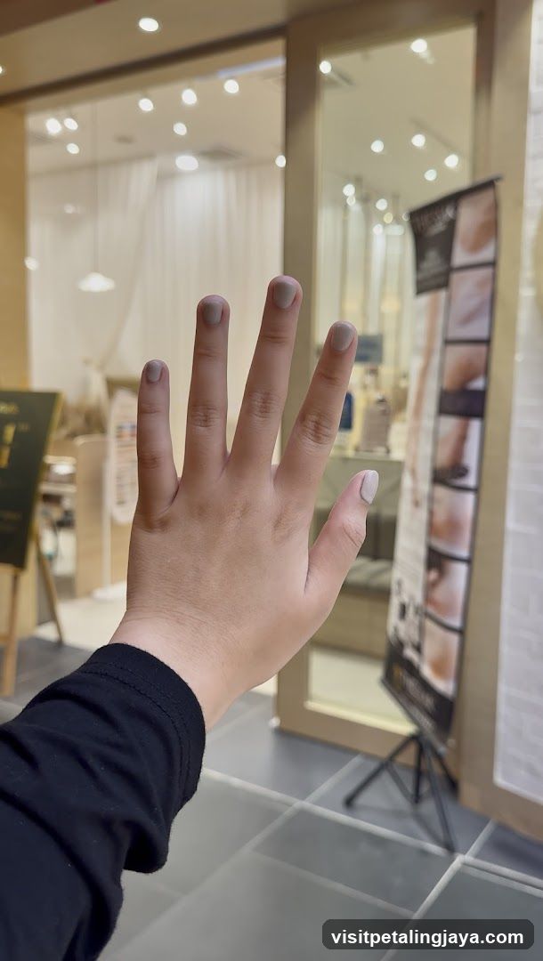 Hand with manicured nails in a salon interior