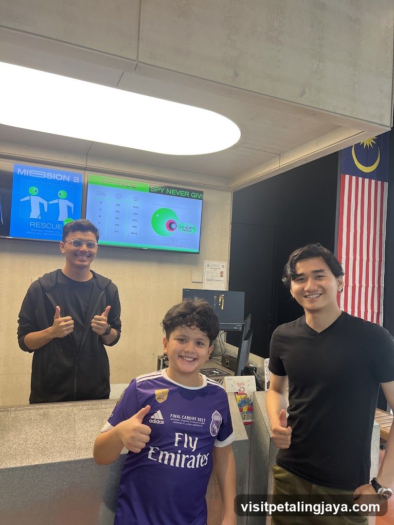 Three people posing in an indoor space with screens and flag