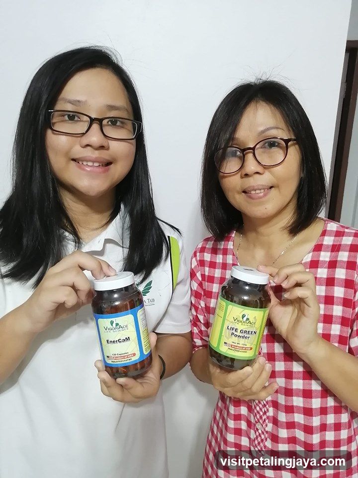 Two women holding health supplement jars