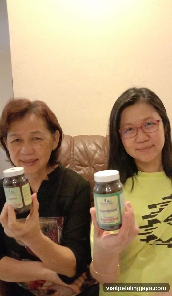 Two women holding supplement bottles