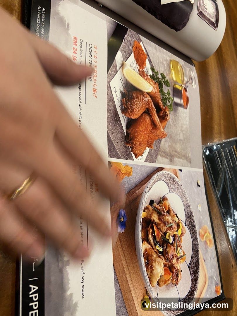 Hand holding a menu with food images