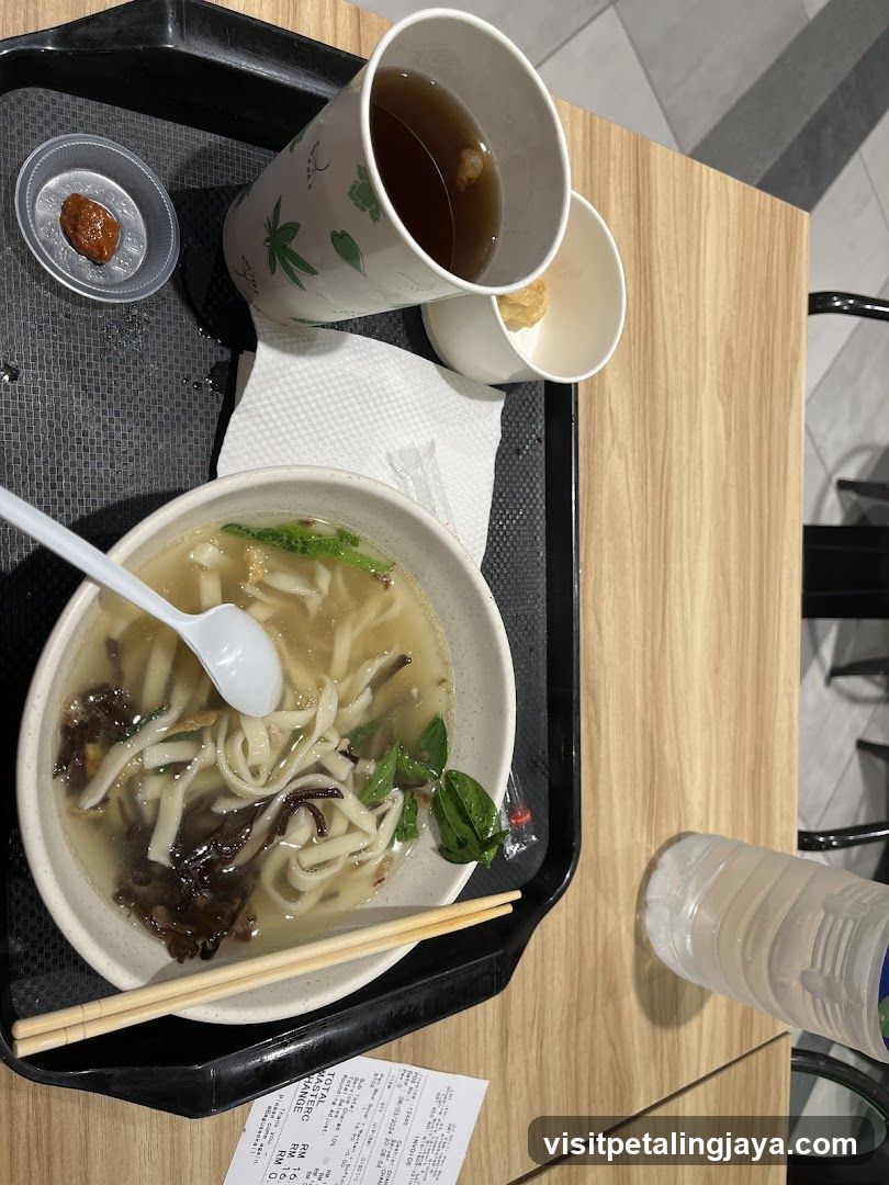 Bowl of noodles with soup and drink on a tray