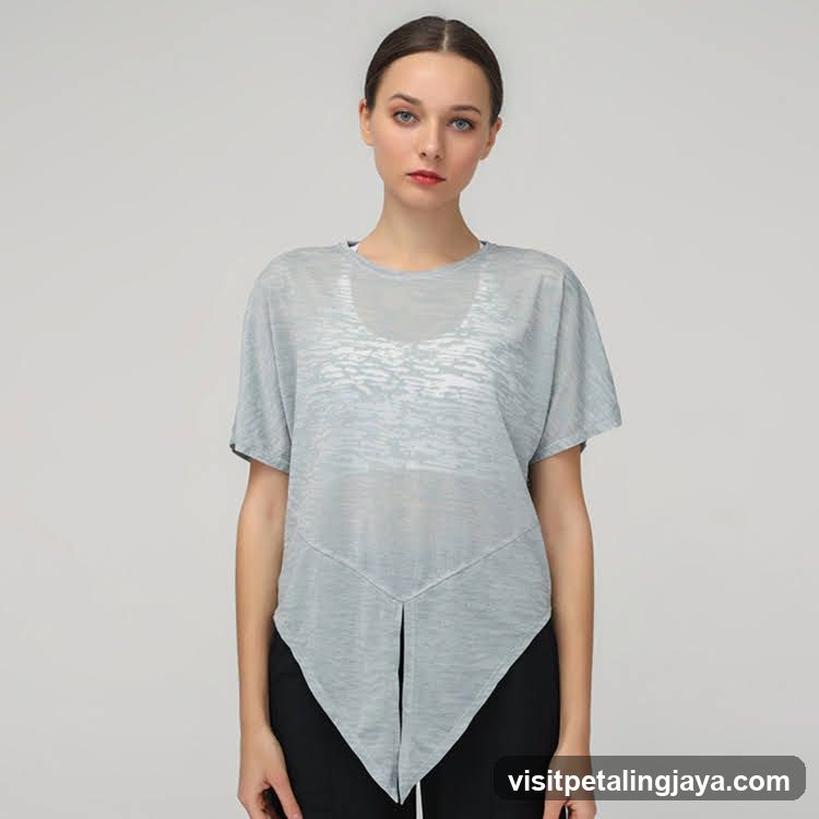 Woman wearing a light blue sheer top with asymmetrical hemline