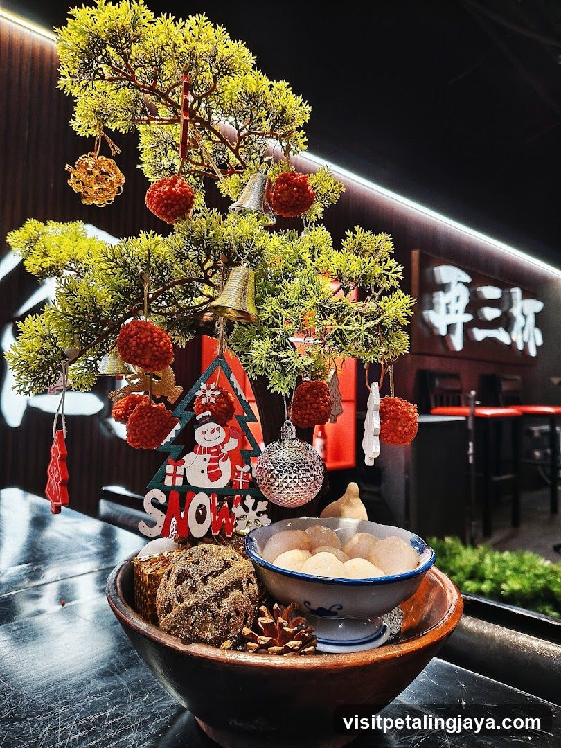 Christmas-themed table display with bonsai tree and snacks