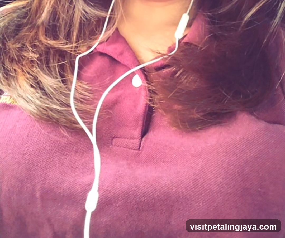 Person wearing maroon polo shirt with white earphones