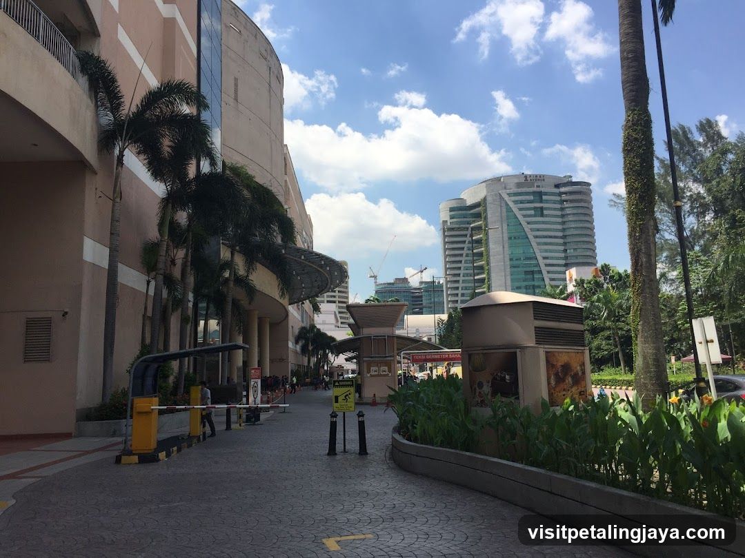 Outdoor Mall Entrance with Palm Trees and Modern Buildings