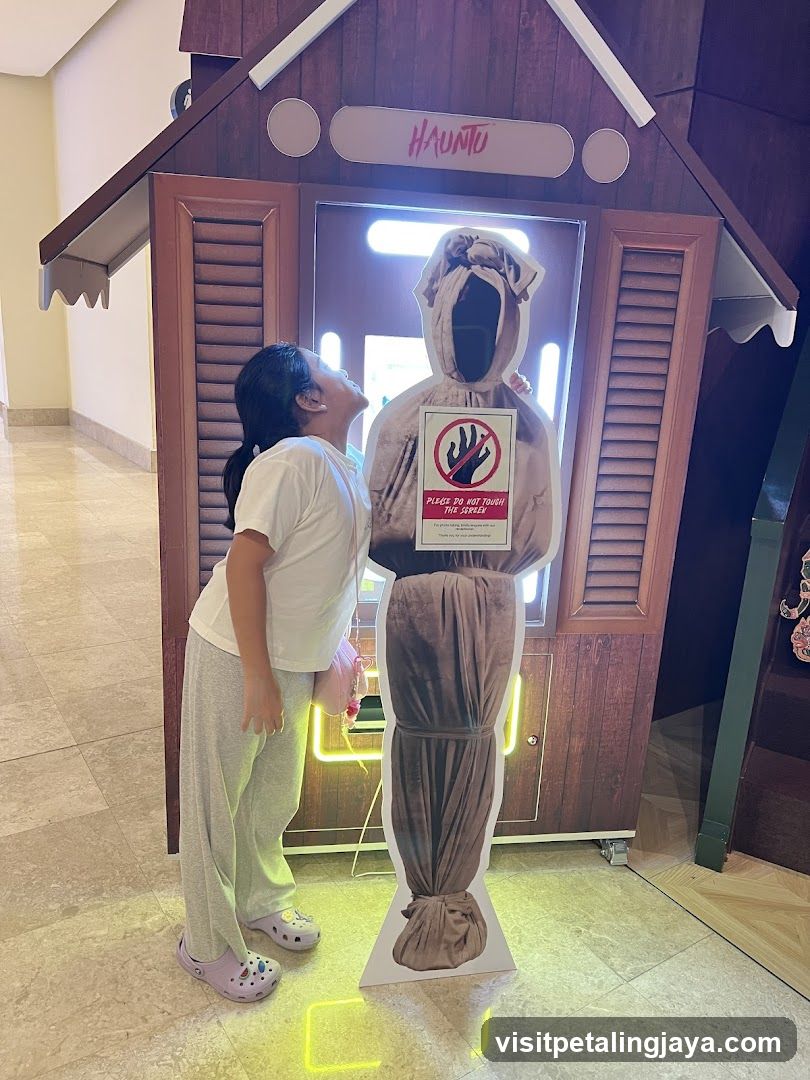 Girl posing with haunted figure cutout