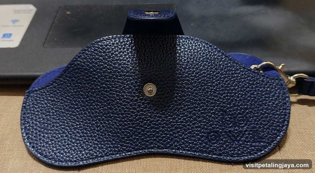 Blue textured pouch with metal clasp and strap